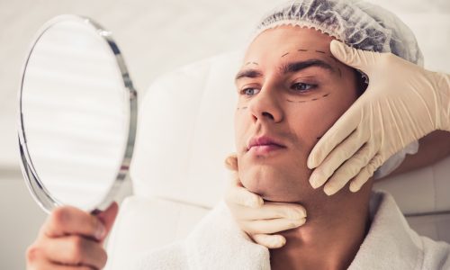 Handsome man is looking into the mirror. Handsome man is looking into the mirror.